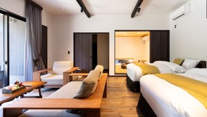 A modern hotel room with a sofa, a bed, a dining table, and a separate dining area. - Auberge Yusura (Ise)