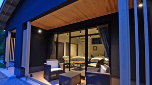 A modern hotel exterior with a covered outdoor seating area, large windows, and a well-maintained garden. - Auberge Yusura (Ise)