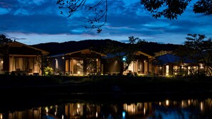 A row of modern houses with large windows and a calm lake in the foreground. - Auberge Yusura (Ise)