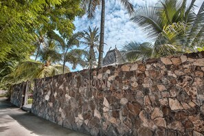 A stone wall with a sign reading "Slow Private Pool Villas."