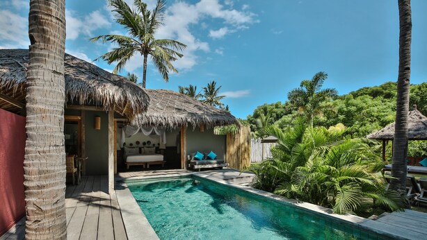 A pool area with a thatched-roof structure, palm trees, and a wooden deck. - Slow Private Pool Villas (Gili Air)