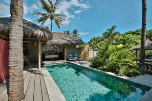 A pool area with a thatched-roof structure, palm trees, and a wooden deck. - Slow Private Pool Villas (Gili Air)