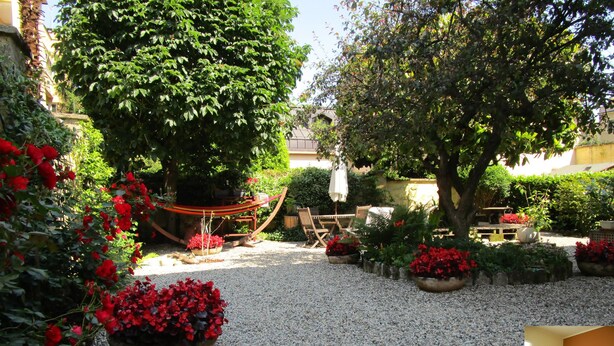A garden with a hammock, outdoor seating, and potted plants. - Colazione da Augusta (Turin)