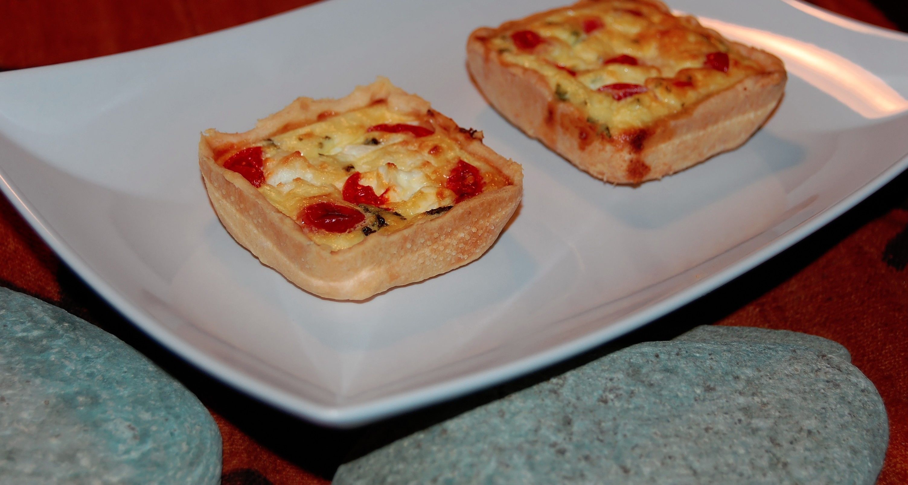 Two square-shaped pastries on a white plate.