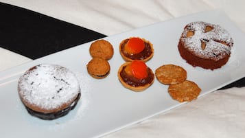Un plato de postres con varias opciones, incluyendo pastel de chocolate, tartas y galletas.