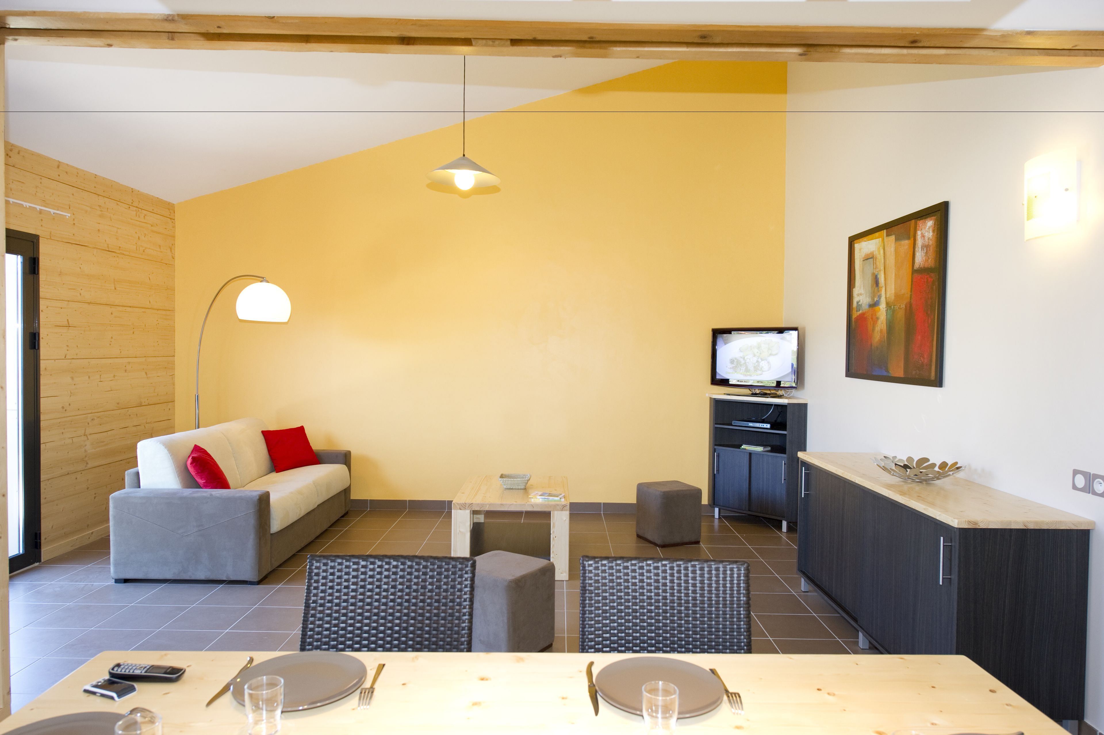 Un salon moderne comprenant un canapé, une table à manger et un coin cuisine.