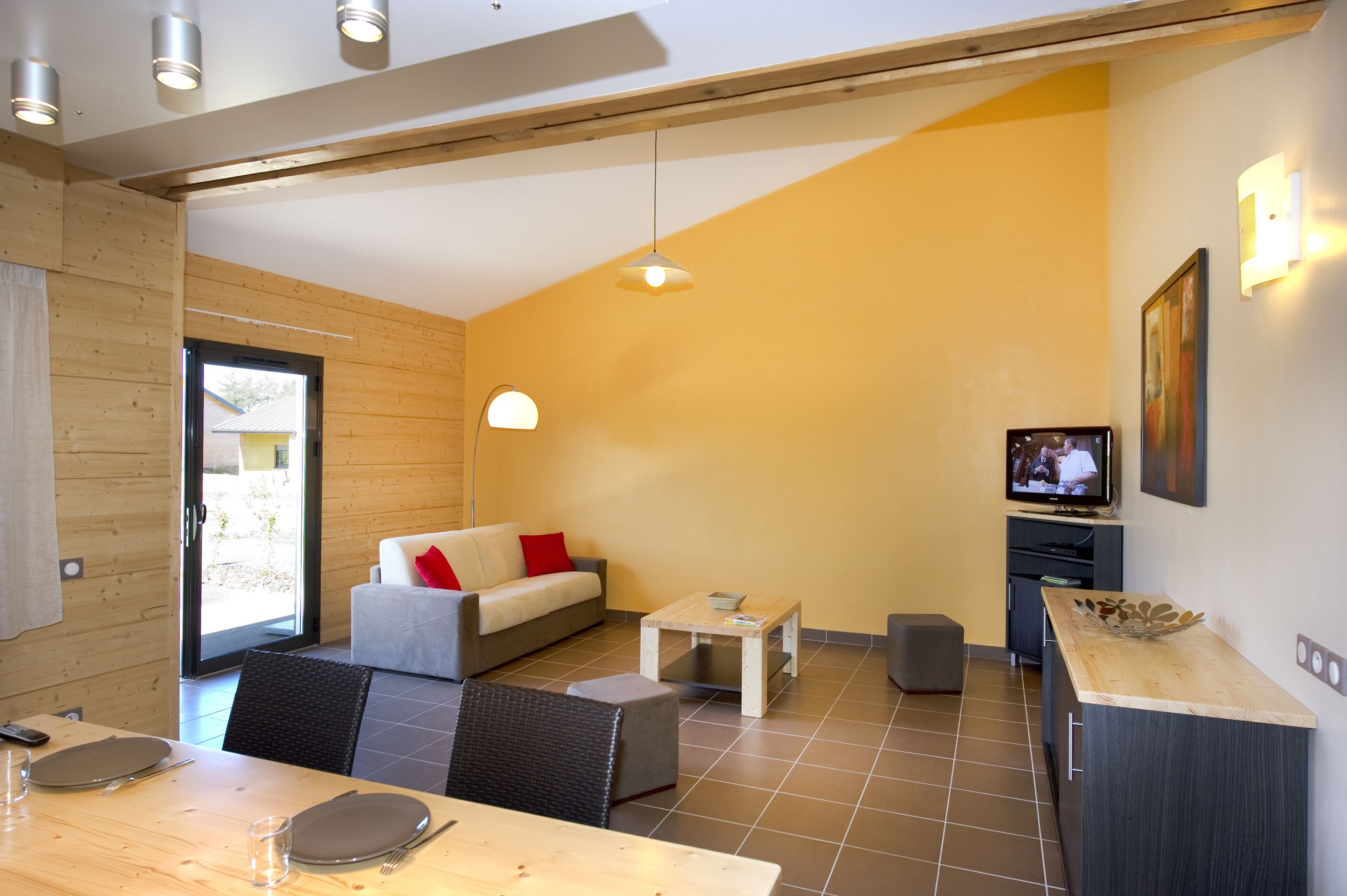 Een moderne woonkamer met een bank, eettafel en televisie.