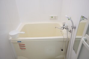 A small, white bathroom with a bathtub, a white toilet, and a white sink. - Takemura House Kyoubashi (Osaka)
