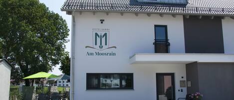 A building with a sign reading "Hotel Carnis Am Moosrain."