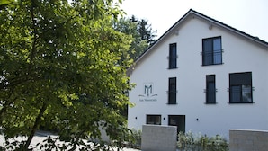 Un bâtiment blanc portant l’enseigne « Hotel Garni Am Moosrain ».