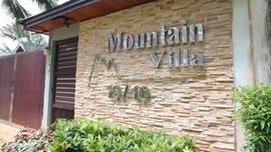 Un mur de pierre sur lequel on peut lire l’inscription « Mountain Villa » et l’adresse « 19/10 ».