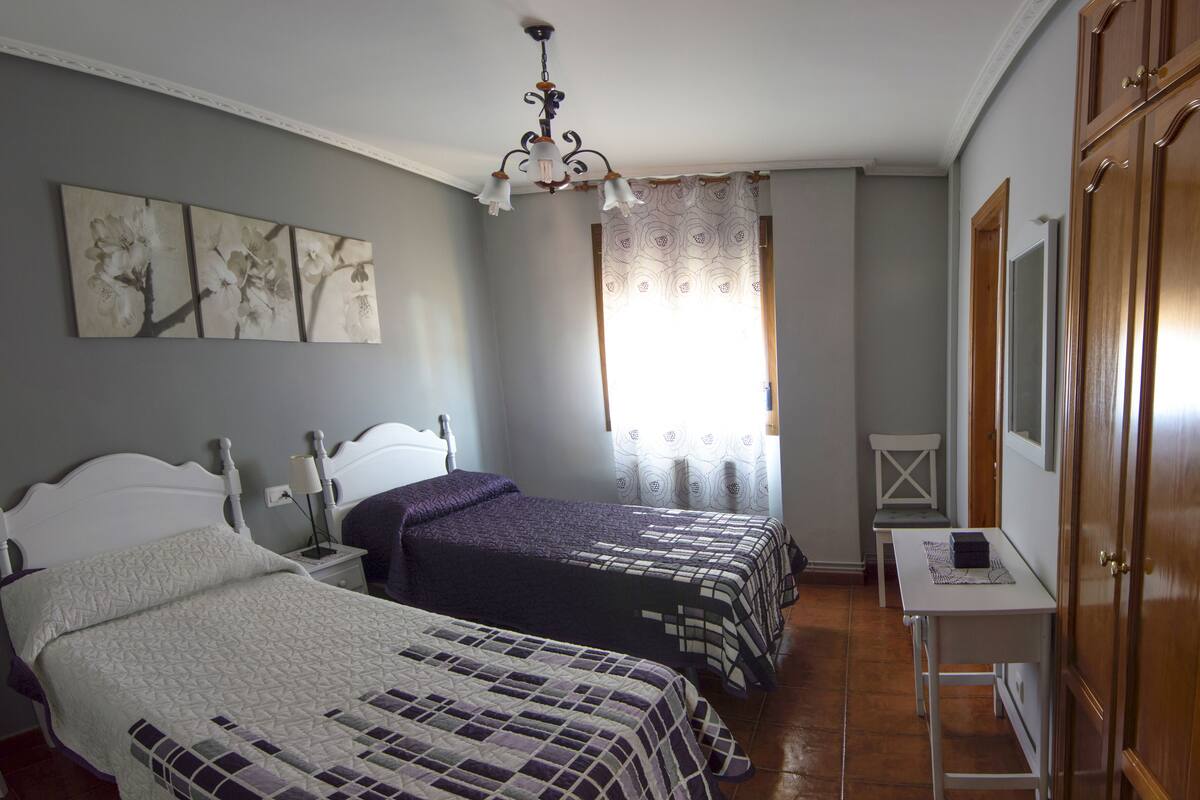 Une chambre avec deux lits, un bureau et une chaise.