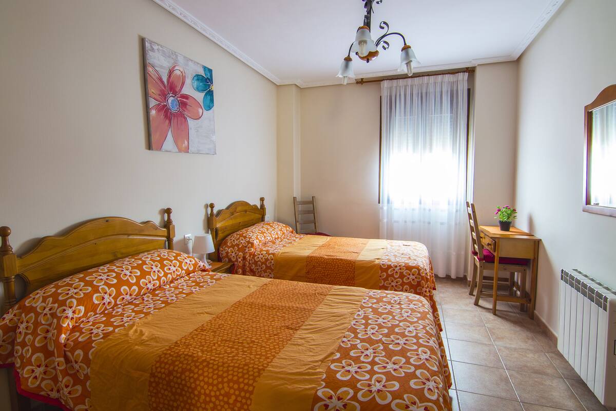 Une chambre avec deux lits, un bureau et une chaise.