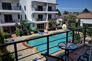 A multi-story hotel with a pool area, including lounge chairs and a table. - Pool Access 89 at Rawai (Rawai)