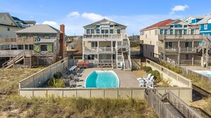A beachfront property with a swimming pool, multiple balconies, and a wooden deck. - Atlantic Watch: Oceanfront | 14 bedrooms | Private Walkway | Heated Private Pool (Kill Devil Hills)