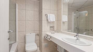 Ein modernes Badezimmer mit Toilette, Waschbecken und Dusche.
