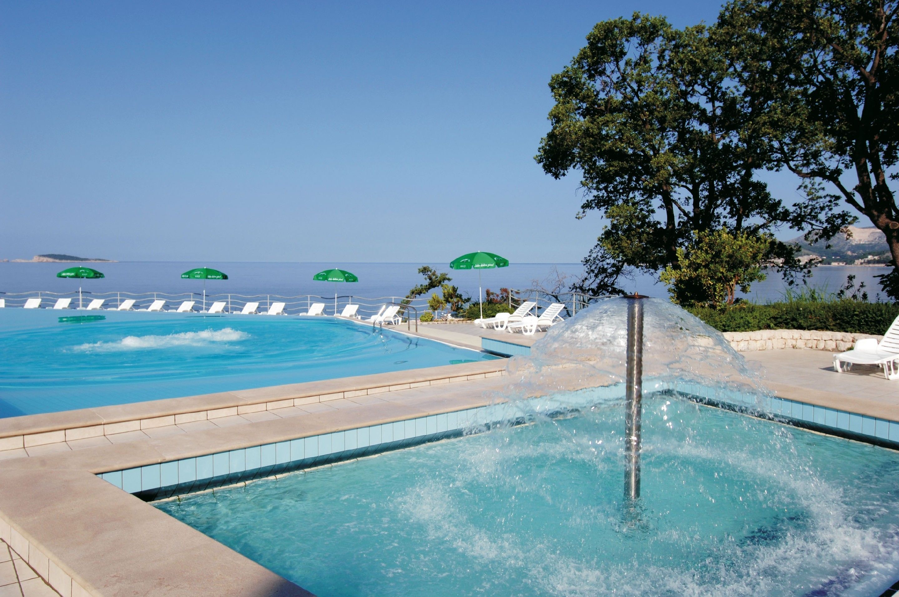 Una piscina al aire libre, sillones reclinables de piscina