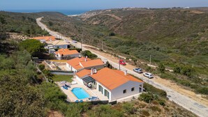 A residential area with houses, a swimming pool, and a road.