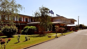 A two-story hotel with a sign indicating it is a hotel. There are well-maintained lawns and a variety of plants in the front yard. - Hotel Petrarca (Boara Pisani)