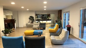 A modern living room with a sofa set, a coffee table, and a dining area in the background. - Hotel Petrarca (Boara Pisani)