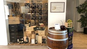 A wine display with wooden crates and bottles, a large barrel labeled 'Monte Del Leno di Mezzana', and a framed certificate on the wall. - Hotel Petrarca (Boara Pisani)