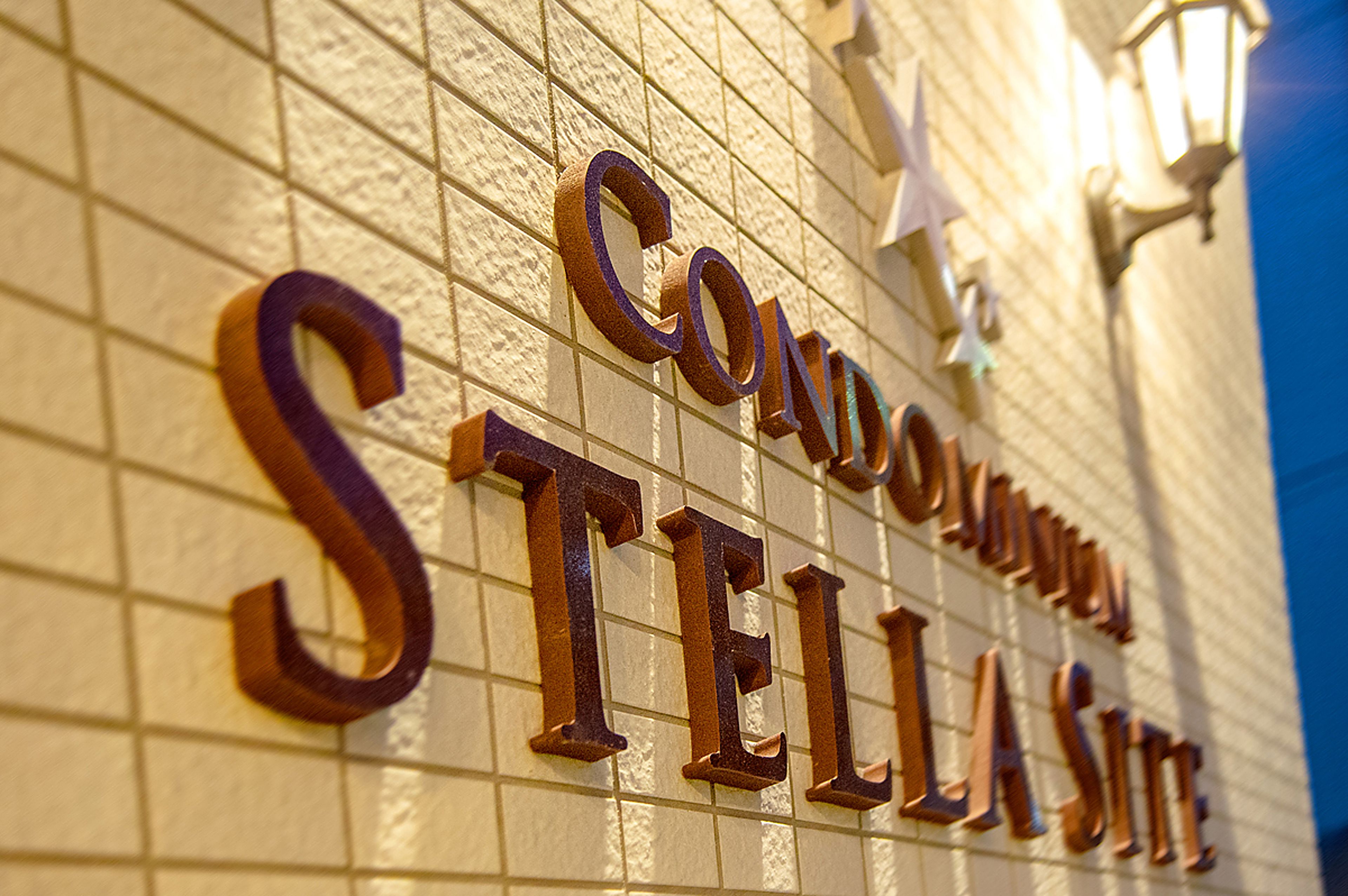 Een bordje met de tekst 'CONDOMINIUM STELLA SITE' op een ruwe muur.