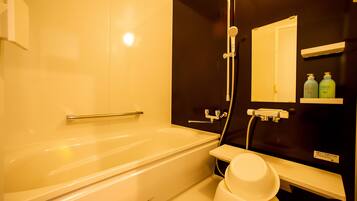 Ein Badezimmer mit Badewanne, Toilette und Spiegel.
