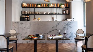 A modern restaurant interior with marble countertops, wooden herringbone flooring, and pendant lighting. - Hebe Hotel (Annecy)