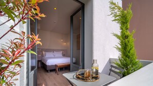 A balcony with a table, a bottle, and a bench. - Hebe Hotel (Annecy)