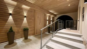 A modern staircase with a metal railing, wooden panel walls, and recessed lighting. - Hebe Hotel (Annecy)