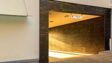 A modern building entrance with a sign for 'Plaza 375 Apart Hotel'.