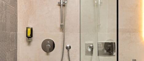 Un baño moderno con ducha de vidrio, inodoro independiente y lavamanos empotrado.