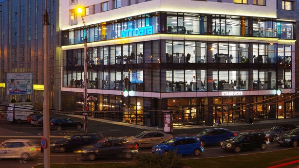 Un hotel de varios pisos con un diseño moderno, que cuenta con un llamativo letrero de 'Piazza 35' y un Starbucks en la planta baja.