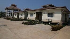 Une rangée de maisons à deux étages, dotées d’une entrée centrale, d’un porche abrité et d’un petit jardin.