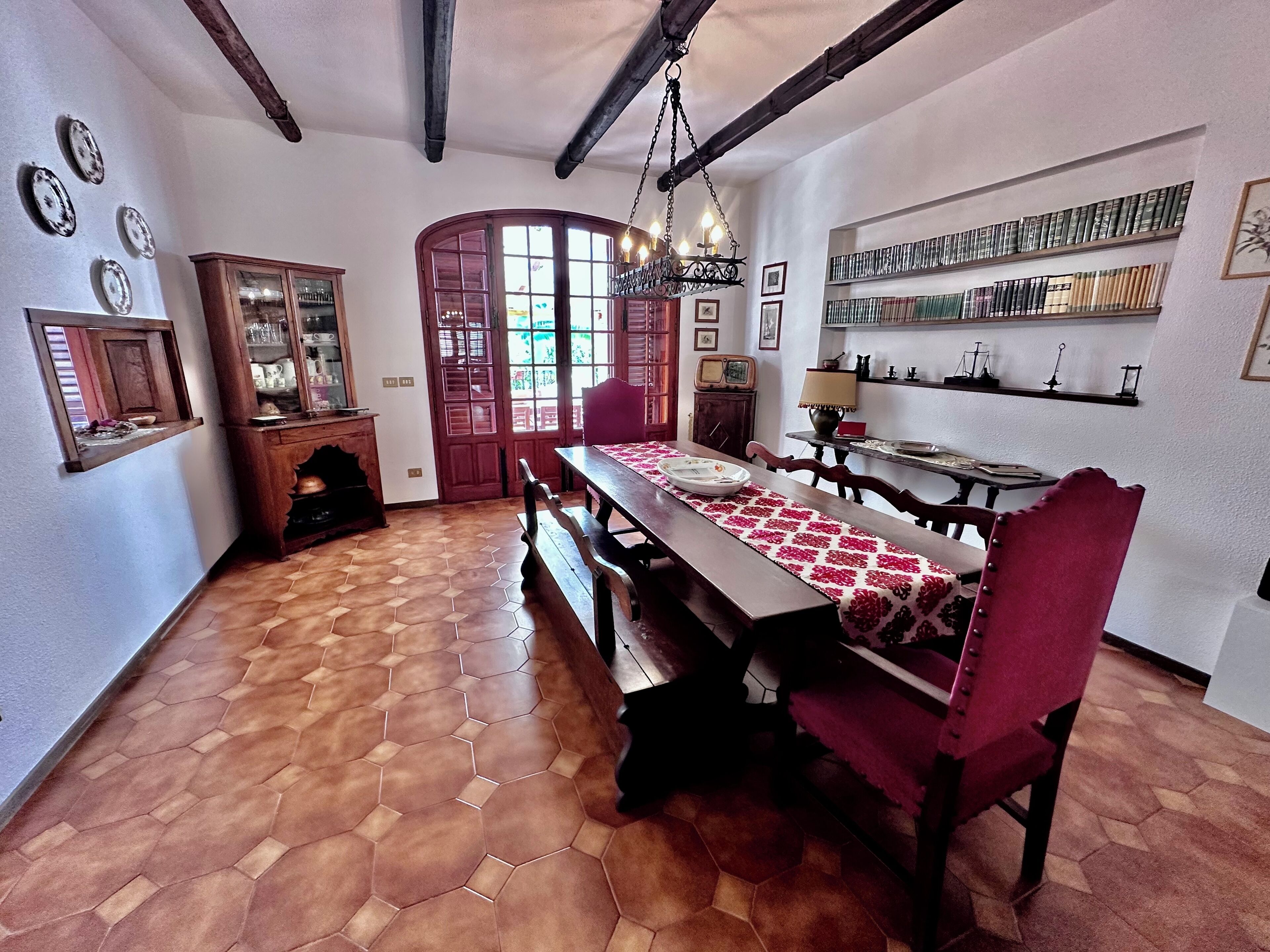 A dining area with a wooden table, chairs, and a hexagonal patterned floor.