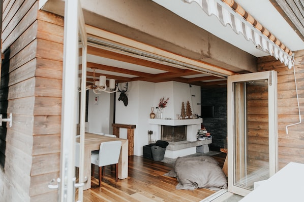 Un interior acogedor con una zona de comedor de madera, una chimenea y un espacio de estar confortable.