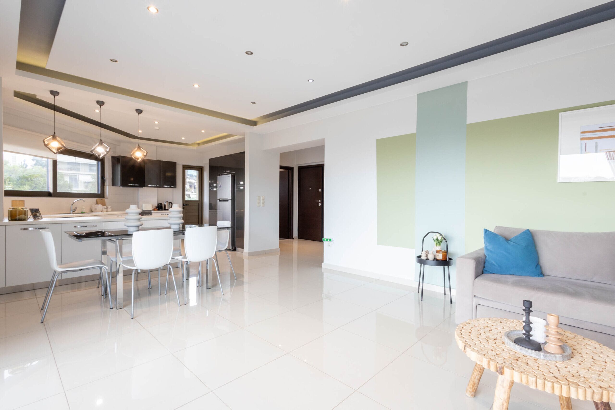A modern hotel lobby with a dining area, a sofa, and a coffee table.