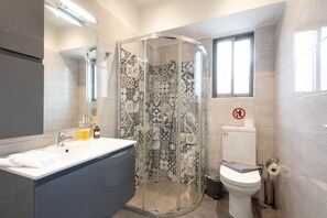 Ein modernes Badezimmer mit Duschkabine, Toilette und Waschbecken mit Spiegel.