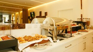 A buffet setup with various food items and a coffee station. - Hotel Concha (Alcobaça)