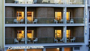 A multi-story CONCIA HOTEL with balconies, outdoor seating, and a visible ground floor entrance. - Hotel Concha (Alcobaça)