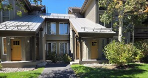 A residential building with a covered walkway, numbered doors, and a well-maintained lawn. - Snowcreek Resort Vacation Rental 848 (Mammoth Lakes)