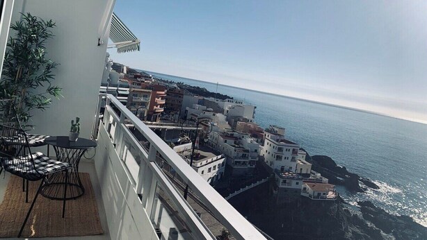 A balcony with a view of the sea and buildings. - Spacious, light & cozy apartments with ocean views (Santiago del Teide)