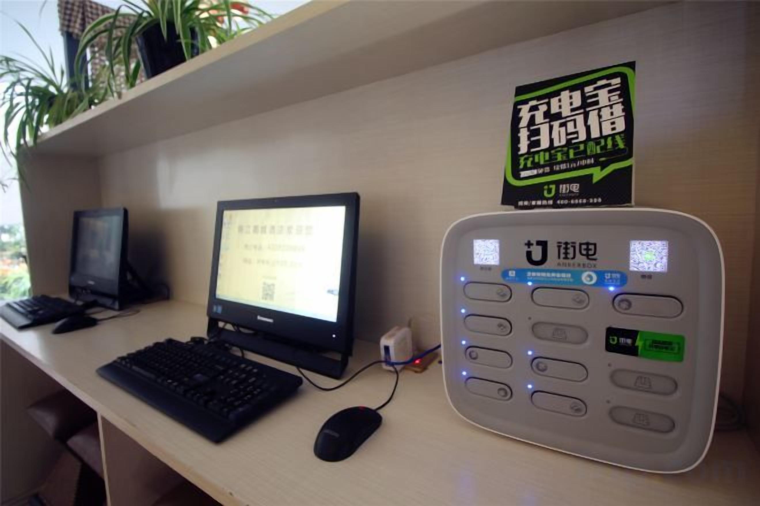 A desk with a desktop computer, a monitor, a keyboard, a mouse, and a payment terminal.