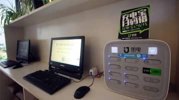 A desk with a desktop computer, a monitor, a keyboard, a mouse, and a payment terminal.
