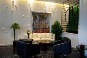 A modern living room with a white sofa, black armchairs, a coffee table, and decorative lighting. - Shanghai Jinshanzui Yucun Hotel (Shanghai)