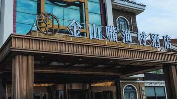 Entrada de hotel com design moderno, destacando uma placa com caracteres chineses.