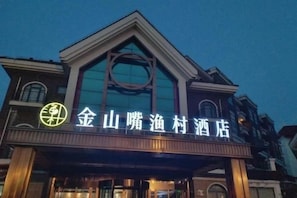 A hotel with a prominent sign and a large glass facade. - Shanghai Jinshanzui Yucun Hotel (Shanghai)