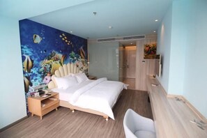 Una habitación de hotel moderna con una cama grande, una mesita de noche, un escritorio y una silla.