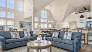 Ein geräumiges Wohnzimmer mit zwei Sofas, einem Couchtisch und einem Essbereich mit Stühlen und Tisch.