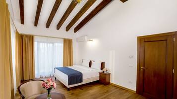 A hotel room with a bed, bedside table, and a chair.
